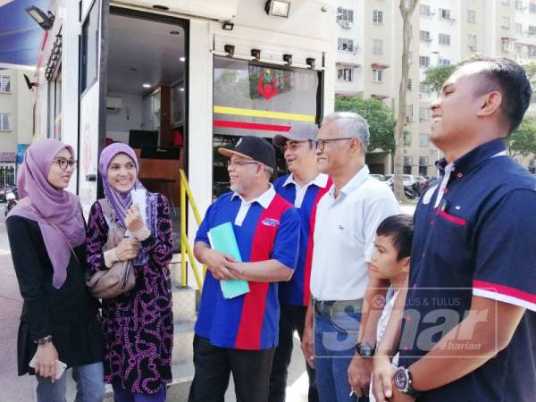 Abdul Hakim (tiga dari kiri) beramah mesra bersama pengunjung di Program Komuniti PPR Pudu Ulu Sebarkan Kebaikan di sini hari ini.