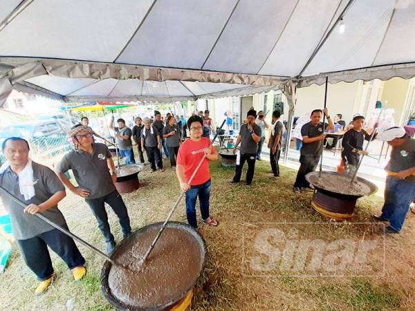 Peserta bergotong-royong menyediakan bubur sugho dalam Majlis Ngaca Sugho anjuran KAKA.