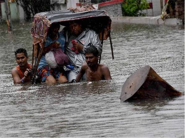 Penduduk meredah banjir yang disebabkan hujan lebat berterusan selama empat hari di timur laut India.