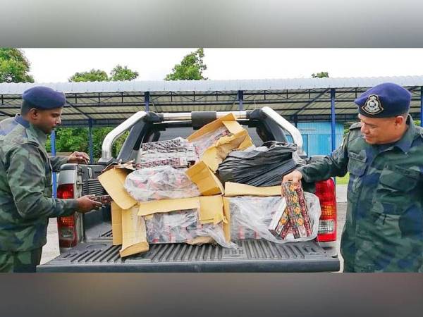 Azhari (kanan) memeriksa rokok yang berjaya dirampas pada sidang media kejayaan rampasan PGA Batalion 7 Kuantan di Markas Taktikal PGA Lubok Stol.