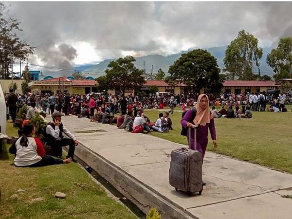 Penduduk yang melarikan diri berkumpul di sebuah padang di Wamena susulan rusuhan yang berlaku di bandar itu. - Foto AFP