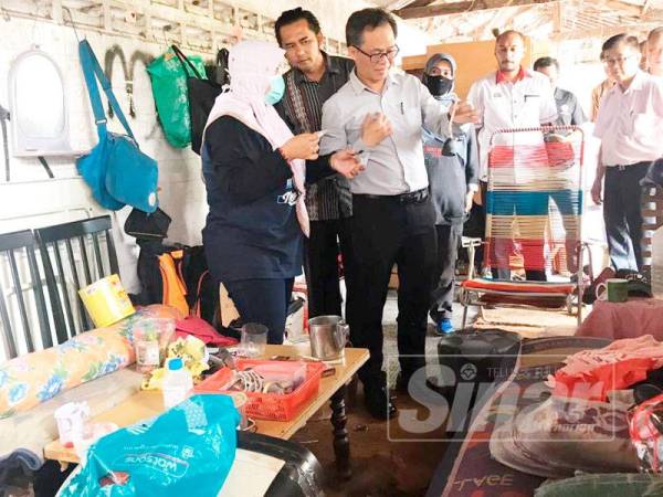 Chee Leong (kanan) melihat keadaan dalam 'rumah sampah' yang menjadi sarang penagihan dadah dan pelacuran sejak empat bulan lalu berhampiran Pangsapuri Taman Kenanga Mewah di sini hari ini.