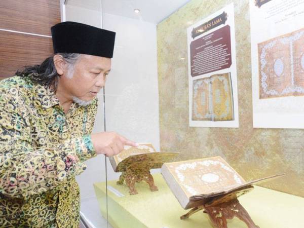 Norhaiza menunjukkan Al-Quran tertua miliknya yang dipamerkan Pameran Iluminasi dan Warkah Emas Diraja Terengganu di Muzium Negeri Terengganu baru-baru ini. - Foto Bernama