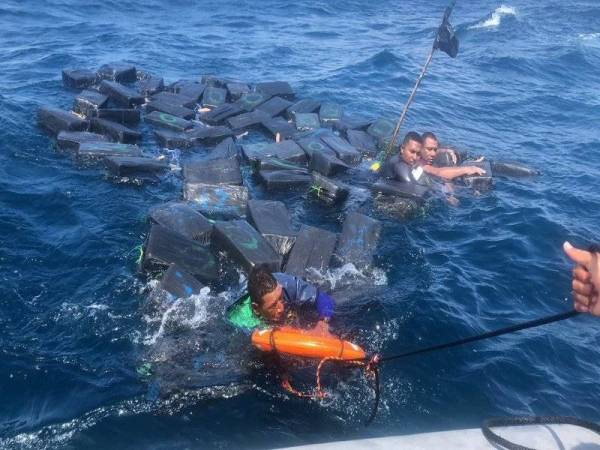 Penyeludup dadah yang berpaut pada bongkah kokain diselamatkan pengawal pantai. - Foto: AFP