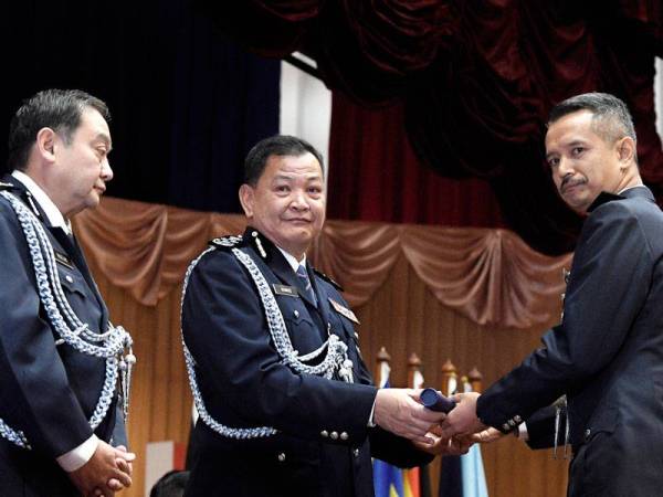 Abdul Hamid (tengah) menyampaikan Ijazah Sarjana Sains Sosial (Pengajian Kepolisan) kepada Superintendan Mohd Hafiz Shamsudin (kanan) di Maktab Polis Diraja Malaysia hari ini. FOTO: BERNAMA