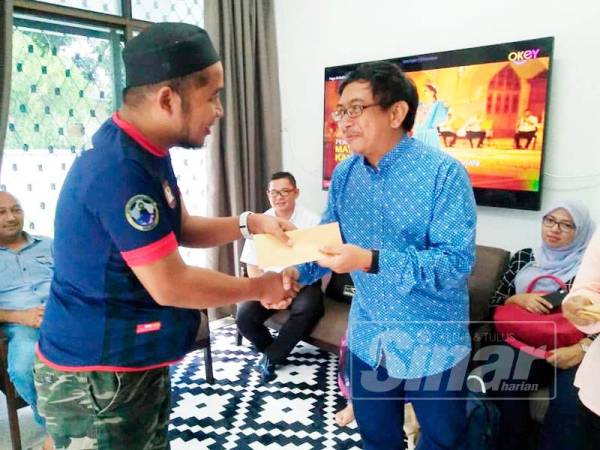 Shahnun (tengah) menyampaikan sumbangan kepada Yatimin di sini.