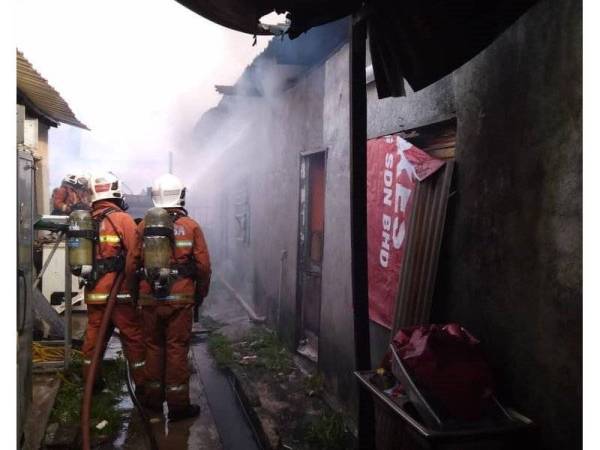 Anggota bomba bertungkus-lumus memadamkan kebakaran di kedai dan rumah terlibat. - Foto JBPM Selangor