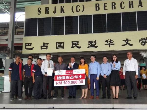 Nie Ching menyerahkan replika cek kepada wakil SJKC Bercham pada Majlis Penyerahan Bantuan Kepada Sekolah Jenis Kebangsaan Cina (SJKC) di SJKC Bercham di sini hari ini.