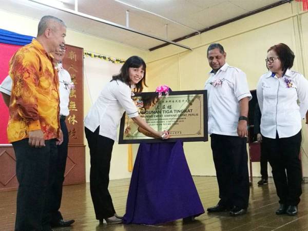 Nie Ching menurunkan tandatangan sebagai simbolik perasmian bangunan baharu tiga tingkat SJKC Simpang Empat di sini semalam.