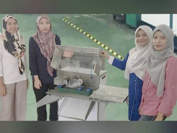 Mastura Saadon (dua dari kiri) menunjukkan mesin pemotong ikan automatik yang dihasilkan bersama barisan penyelidik UTeM.