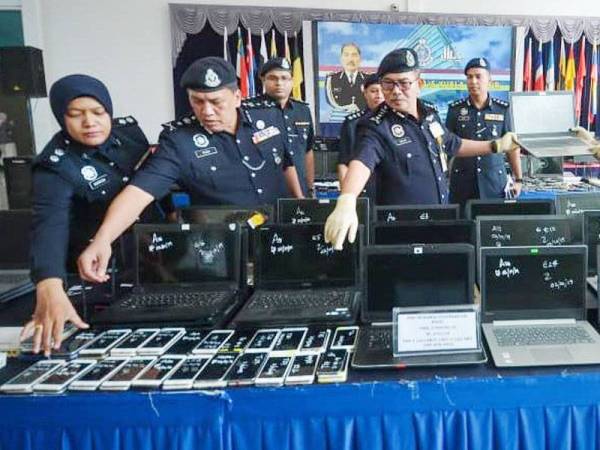 Mazlan (tiga dari kiri) menunjukkan barang-barang rampasan pada sidang media Kejayaan Polis Kuala Lumpur dalam memerangi Perjudian dalam talian (calling centre) di IPK Kuala Lumpur hari ini. - FOTO SHARIFUDIN ABDUL RAHIM