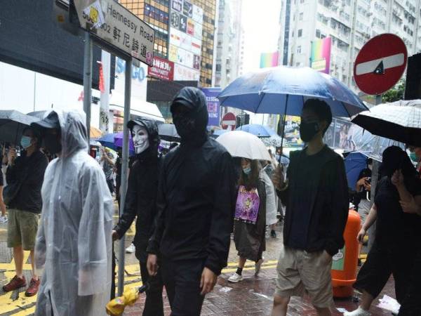 Ribuan peserta protes memakai topeng muka membanjiri daerah Causeway Bay selepas keputusan mahkamah tersebut. - Foto AFP