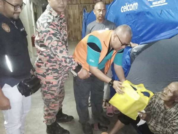 Shamsul Izrin mengagihkan bantuan kepada mangsa banjir yang terjejas. - Foto JKM