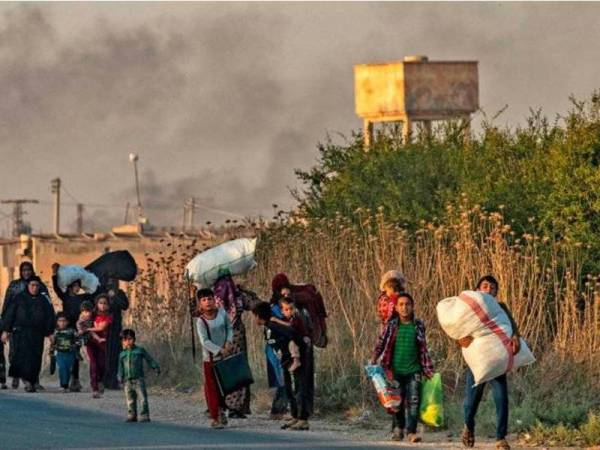 Orang awam melarikan diri susulan pengeboman Turki di bandar Ras al-Ain, Syria. - Foto AFP