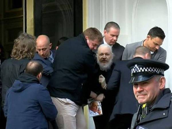 Julian Assange (tengah) ketika diheret keluar dari kedutaan Ecuador di London pada April lalu. - Foto Ruptly