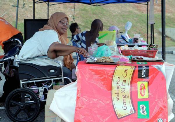 Wanita Orang Kurang Upaya (OKU) Azizah Ahmad, 49, menjual keropok lekor goreng bagi membantu menambah pendapatan untuk menyara keluarga semasa ditemui di gerainya, hari ini. -Foto Bernama