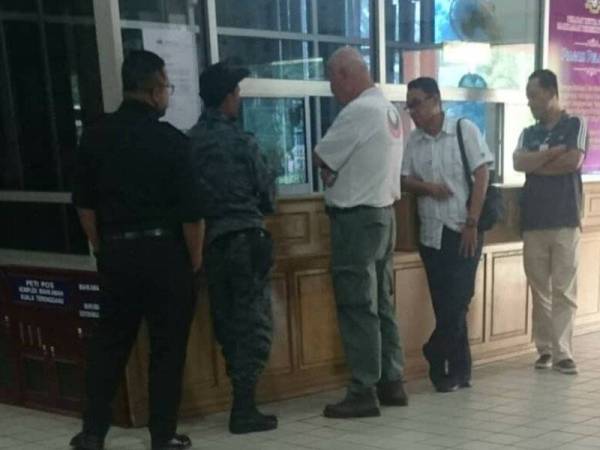 Hun Chang (tengah) dan Mohd Azrul Fajri (kanan) sedang menguruskan prosedur untuk pembayaran denda di kaunter Kompleks Mahkamah di sini.