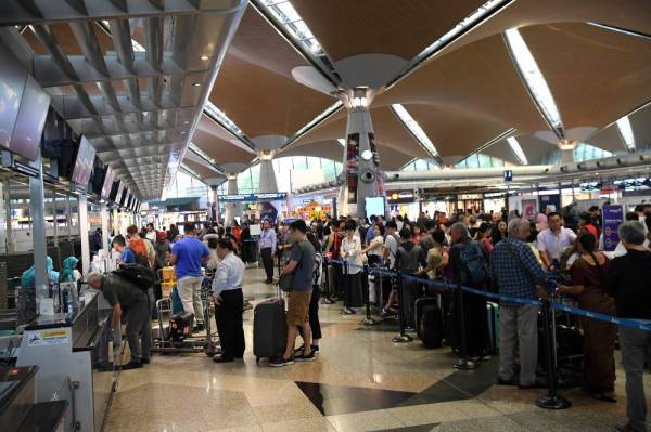 Petugas Malaysia Airports membantu para penumpang yang memenuhi ruang kaunter pendaftaran masuk KLIA yang mengalami gangguan sistem antara lain mengakibatkan kelewatan penerbangan di KLIA Ogos lalu.
