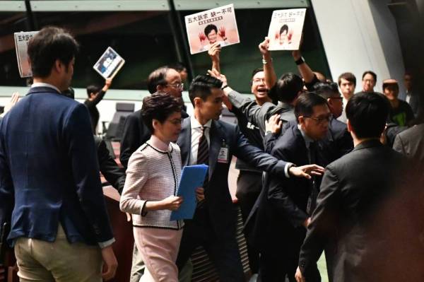 Lam (dua daripada kiri) meninggalkan dewan tersebut selepas gagal membentangkan dasar tahunan di Legco di Hong Kong hari ini. - Foto: AFP
