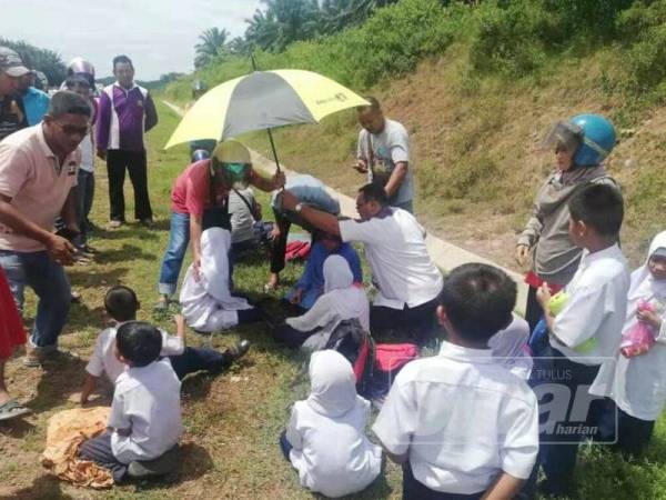 Orang ramai memberi bantuan awal kepada murid yang terlibat dalam nahas di KM13.8 Jalan Sungai Petani-Kuala Ketil.