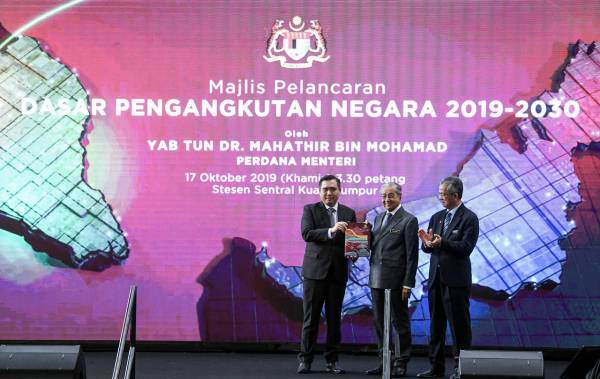 Dr Mahathir menunjukkan buku Dasar Pengangkutan Negara 2019-2030 pada Majlis Pelancaran Dasar Pengangkutan Negara di Stesen Sentral Kuala Lumpur hari ini.  -Foto Bernama