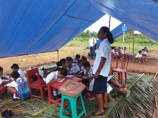 Kanak-kanak kawasan gempa tetap bersemangat belajar di khemah-khemah sementara yang hanya beralaskan daun kelapa. -Foto Agensi