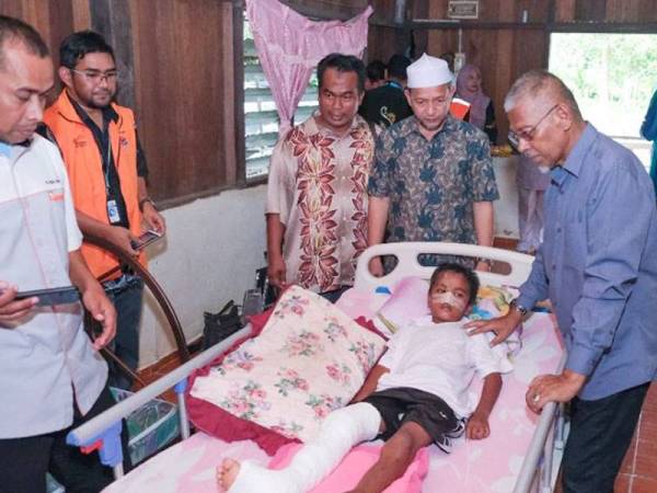 Hanafiah (tiga dari kanan) melihat Muhammad Darwish Iqbal tidur di katil baharu sumbangan Pas DUN Bukit Besi. 