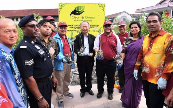 Dr Mujahid (empat, kanan) menanam pokok bakau pada Program 'Clean and Green: Rahmah For All' di Kampung Pulau Ketam, hari ini. -Foto Bernama