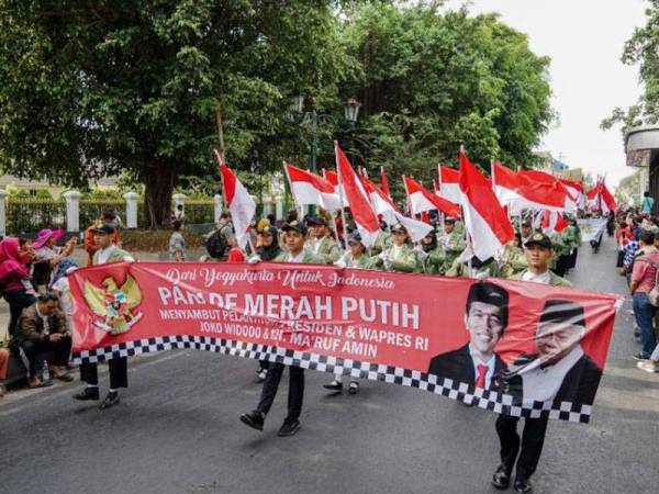 Penduduk mengambil bahagian dalam perarakan bagi meraikan angkat sumpah Jokowi semalam. - Foto AFP