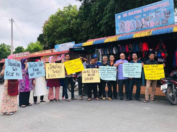 Sembilan peniaga mengadakan demonstrasi aman di hadapan kedai mereka.