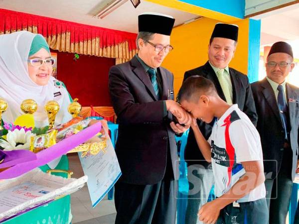 Zainuddin (dua dari kiri) mahu pelajarnya sentiasa mengimbangi kejayaan sukan dan akademik.