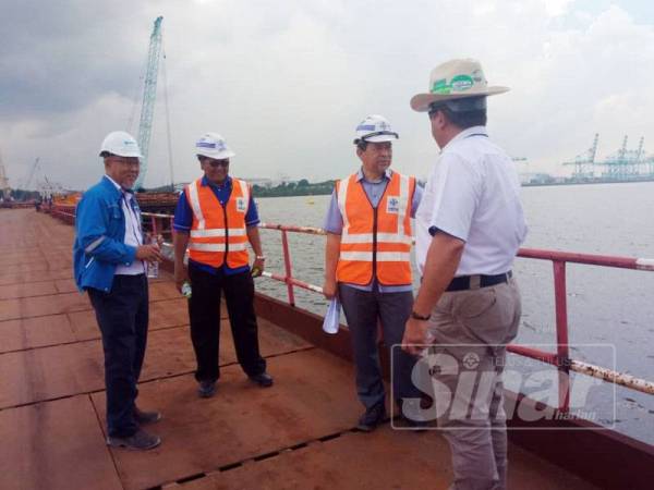 Mohd Solihan ( dua dari kanan) meninjau tapak projek jambatan merentasi Sungai Pulai di sini.