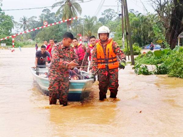 Anggota bomba memindahkan penduduk menggunakan bot ke kawasan lebih selamat. -FOTO: IHSAN JABATAN BOMBA DAN PENYELAMAT