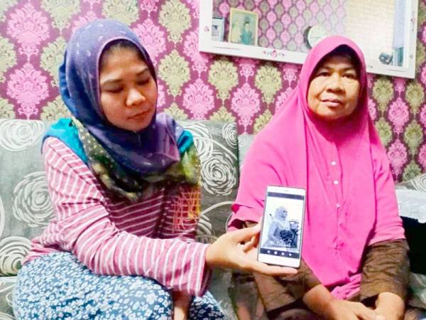 Norhafizah menunjukkan gambar Allahyarhamah Norfazera yang tular di media sosial dan berharap netizen tidak lagi berkongsi gambar-gambar arwah adiknya.