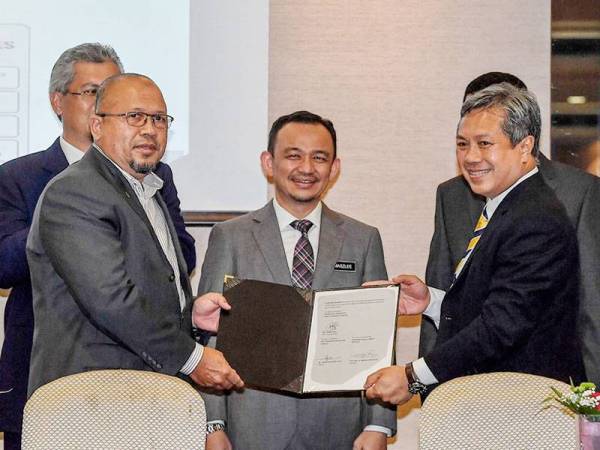 Menteri Pendidikan Dr Maszlee Malik menyaksikan perjanjian usahasama Program Kolaborasi Industri (ICP) MTD Construction-UniKL MICET antara MTD Construction Sdn Bhd yang diwakili Pengarah Urusannya Ahmad Tarmizi Ismail (kiri) dan Universiti Kuala Lumpur yang diwakili presidennya Datuk Dr Mazliham Mohd Su'ud (kanan) pada Majlis Menandatangani Perjanjian Sekunder ICP dan Penyerahan Cek Technology Depository Agency (TDA) di Pusat Persidangan dan Acara Connexion hari ini. - Foto Bernama