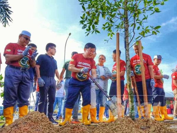 Kon Yeow (tengah) menanam pokok sempena ulang tahun ke-50 PDC di Penang Science Park-North.