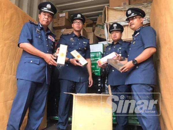 Mohammad Hamiddan (kiri) bersama petugas Kastam Johor menunjukkan antara barangan rampasan yang diperoleh dalam operasi itu.