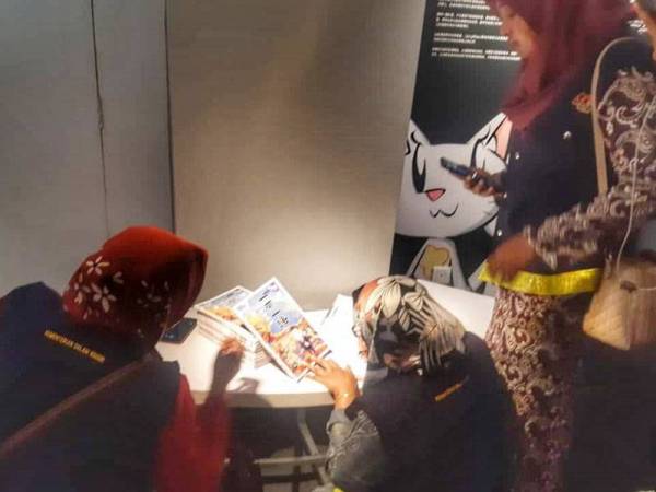 Anggota KDN sedang memeriksa komik ketika serbuan di muzium tersebut pagi tadi.