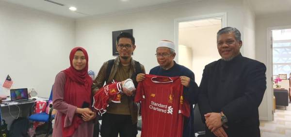 Dr Zulkifli (dua dari kanan) menerima hadiah jersi Liverpool.