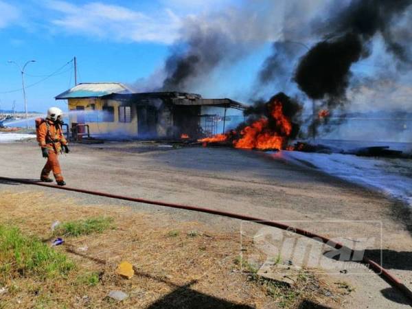 Pihak bomba berusaha memadamkan kebakaran di rumah pam diesel yang beroperasi di LKIM, Chendering. - Foto Bomba