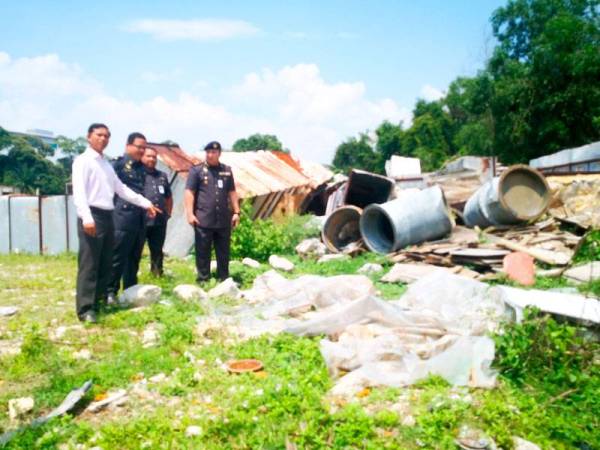 Nordin (kiri) menunjukkan sampah haram yang dibuang di Taman Jasmin.