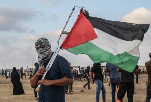 Seorang penunjuk perasaan memegang bendera Palestin. - Foto AFP