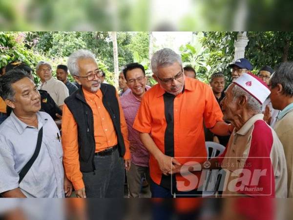 Khalid (dua dari kanan) bermesra dengan seorang warga emas pada Majlis Ramah Mesra dan Jamuan Rakyat di Kampung Pak Madah hari ini.