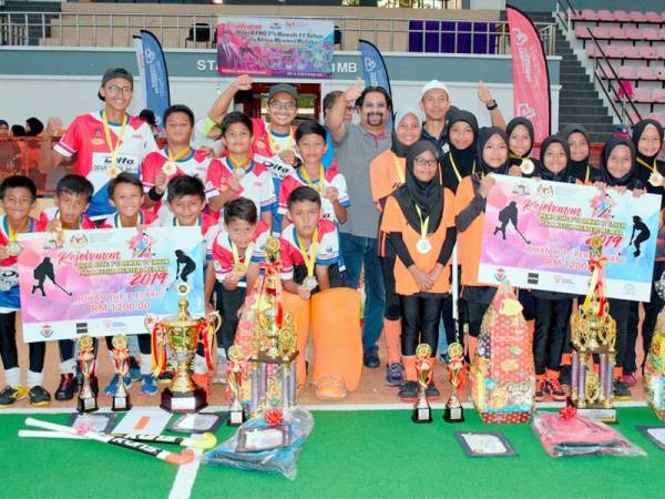 Subahan (tengah) bersama Juara Skuad Lelaki pasukan DP Tigers dari Sekolah Kebangsaan Desa Petaling (kiri) dan Skuad Perempuan pasukan Bemban Tigres dari Sekolah Kebangsaan Seri Bemban (kanan) selepas Majlis Penutup Kejohanan Hoki Piala Ketua Menteri Melaka di Bukit Serindit semalam. - Foto Bernama