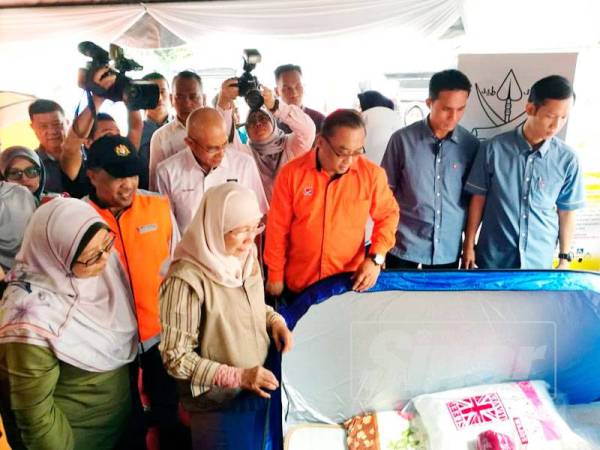 Wan Azizah meninjau keperluan yang disediakan untuk mangsa banjir di Depoh Simpanan Keperluan Bencana, Kompleks Penyayang JKM dekat sini hari ini.