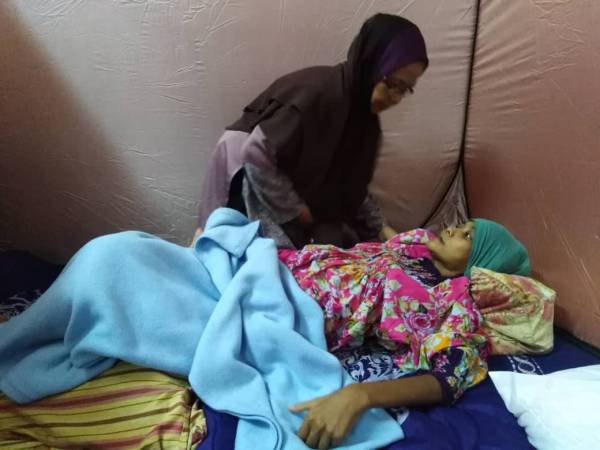 Sharifah menguruskan Marsyitah di PPS SK Parit Mahang, Jeram susulan banjir melanda kampung itu sejak 23 Oktober lalu.
