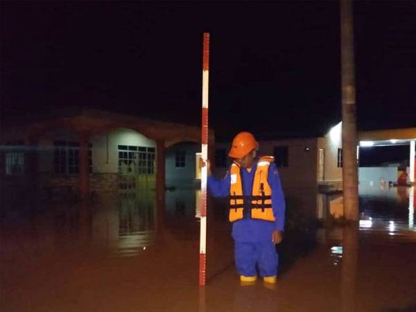 Anggota APM sedang menyukat paras air di kawasan terlibat malam tadi.