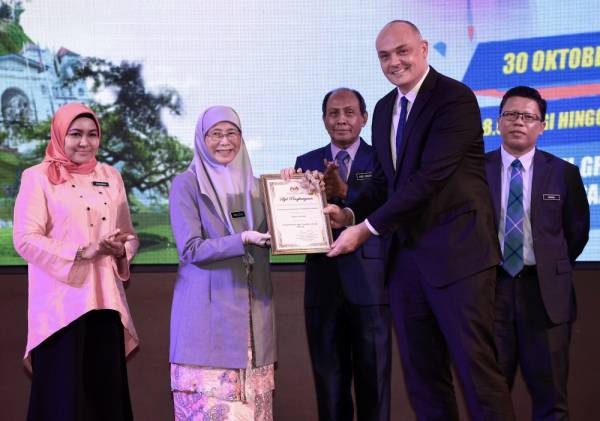 Dr Wan Azizah (dua, kiri) menyampaikan Sijil Penghargaan Rakan Strategi kepada Wakil Program Pembangunan Pertubuhan Bangsa-Bangsa Bersatu Niels Knudsen (dua, kanan) selepas pelancaran Projek Rintis Age-Friendly City@Taiping di sebuah hotel hari ini. -Foto Bernama