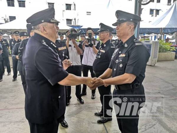 Roslee (kiri) menyampaikan sijil penghargaan Ketua Polis Pulau Pinang kepada anggota yang terpilih.