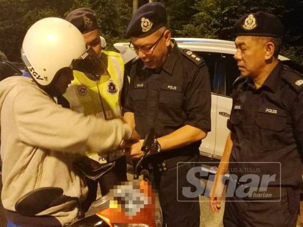 Noor Halim (tengah) sedang membuat pemeriksaan terhadap salah seorang penunggang motosikal ketika Operasi Bersepadu Perayaan Deepavali di Jambatan Sultan Mahmud malam tadi.